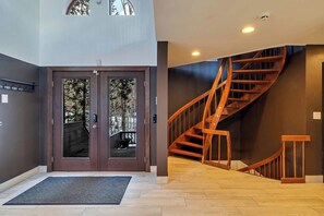 A modern interior with a wooden staircase and a double door with glass panels. - Waterfall Views! Hot Tub, Game Room, Dog Friendly (Bushkill)