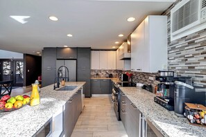 A modern kitchen with granite countertops, stainless steel appliances, and a built-in oven. - Waterfall Views! Hot Tub, Game Room, Dog Friendly (Bushkill)