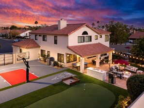 A residential property with a basketball court, outdoor seating area, and a well-maintained lawn. - Epic Getaway! Pool Slide | Sportscourt | Heated Pool | Gameroom (Scottsdale)