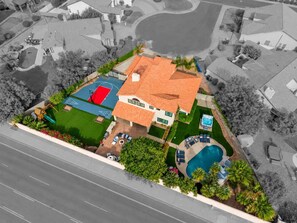 A residential property with a swimming pool, a tennis court, and a landscaped garden. - Epic Getaway! Pool Slide | Sportscourt | Heated Pool | Gameroom (Scottsdale)