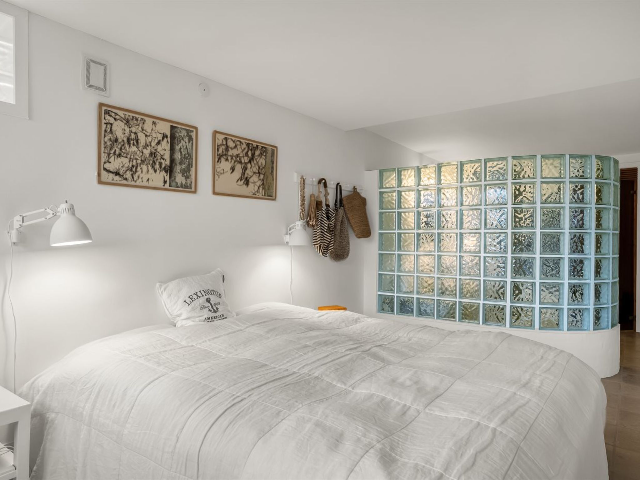 Ein Schlafzimmer mit einem großen Bett, einem Schreibtisch und einem Fenster mit blauem Gittermuster.