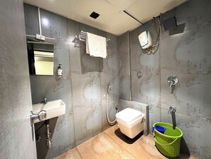 Uma casa de banho moderna com sanita, lavatório e chuveiro.