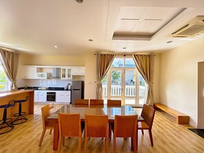 A compact kitchen with white cabinets, a microwave, and a refrigerator. - Deluxe Soan Villa - Sealinks Mui Ne (Phan Thiet)