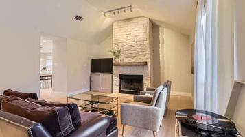 Televisión, chimenea, libros y oficina