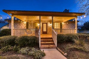 A stone house with a covered porch and a staircase leading to the entrance. - The Cornerstone Cottage - steps from the Square! (Georgetown)