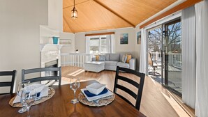 A dining area with a wooden table, chairs, and a fireplace. - Pleasant Cove | Waterfront Getaway with Fire Pit, Deck, and Lake Views (Mooresville)