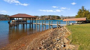 A lakeside pier with a gazebo, a dock, and a covered area. - Pleasant Cove | Waterfront Getaway with Fire Pit, Deck, and Lake Views (Mooresville)