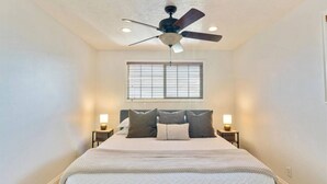 A bedroom with a bed, a ceiling fan, a window with blinds, and bedside lamps. - Canyon Ridge Getaway | Arcade| View | Free Massage* (Cedar Hills)