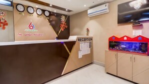 A reception area with clocks, a TV, and a fish tank. - The Ganga Residency (Barh)