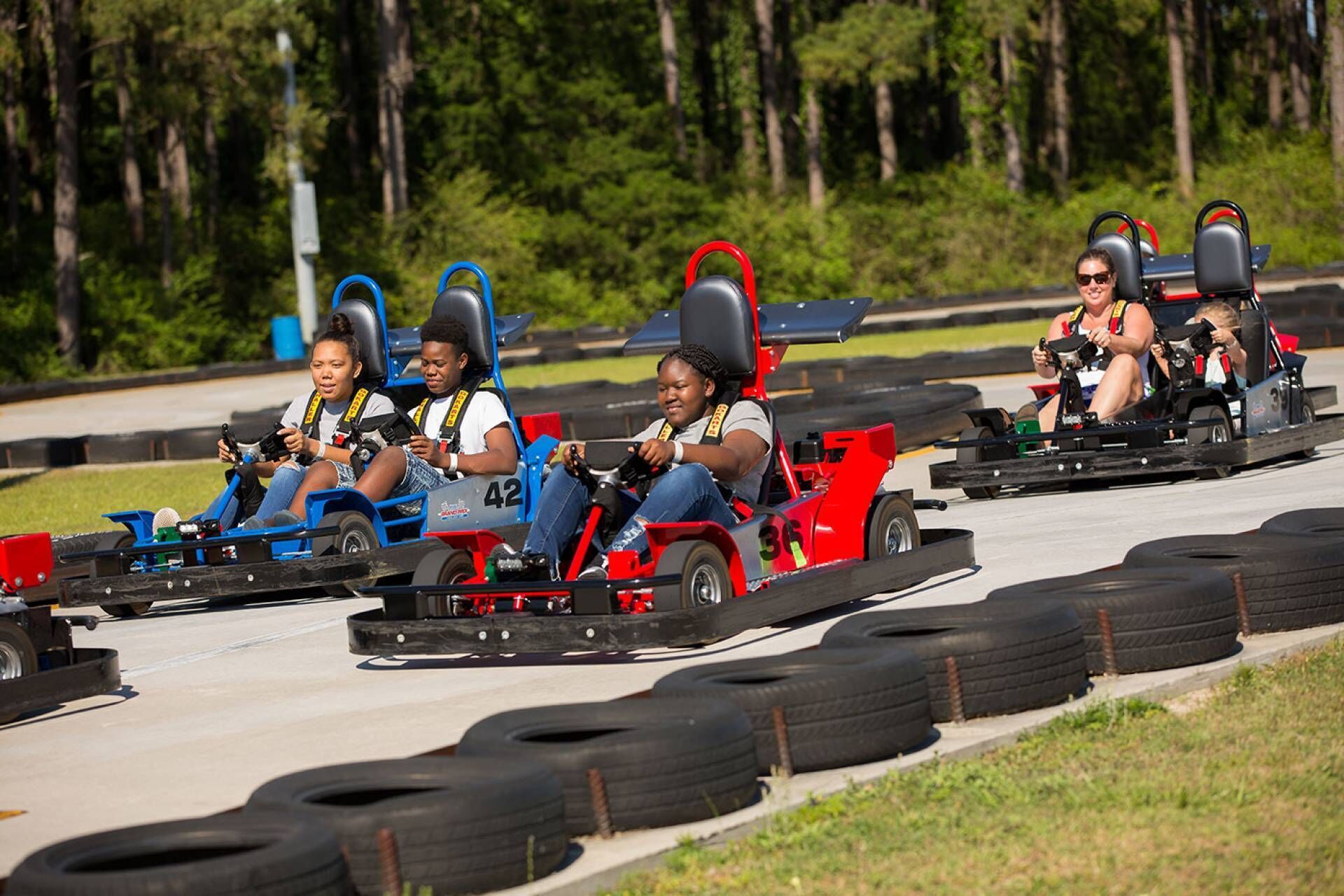 A go-kart track with multiple go-karts and riders.