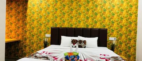 A hotel room with a bed, a wall air conditioner, and a patterned wallpaper.