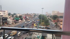 A busy urban street with various vehicles and buildings. - Sojourn Inn (Lucknow)