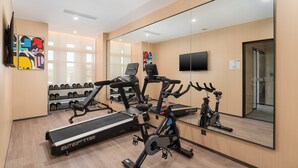 A modern gym with cardio machines, weightlifting equipment, and a mirrored wall. - Holiday Inn Express Guangzhou University Town by IHG (Guangzhou)