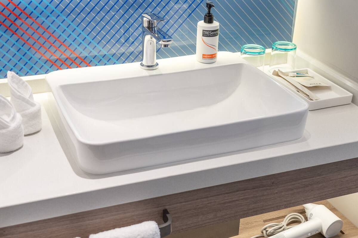 A bathroom with a white sink, a mirror, and a towel rack.