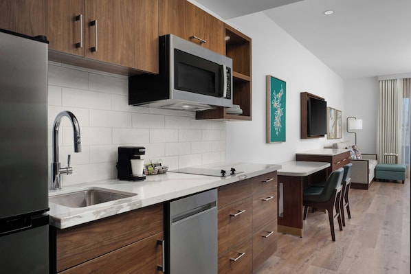 A modern kitchen with stainless steel appliances, wooden cabinets, and a marble countertop. - TownePlace Suites by Marriott Ventura Oxnard (Oxnard)
