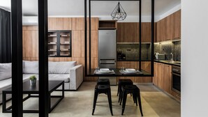 Una cocina moderna con armarios de madera, horno empotrado y comedor con mesa y sillas.