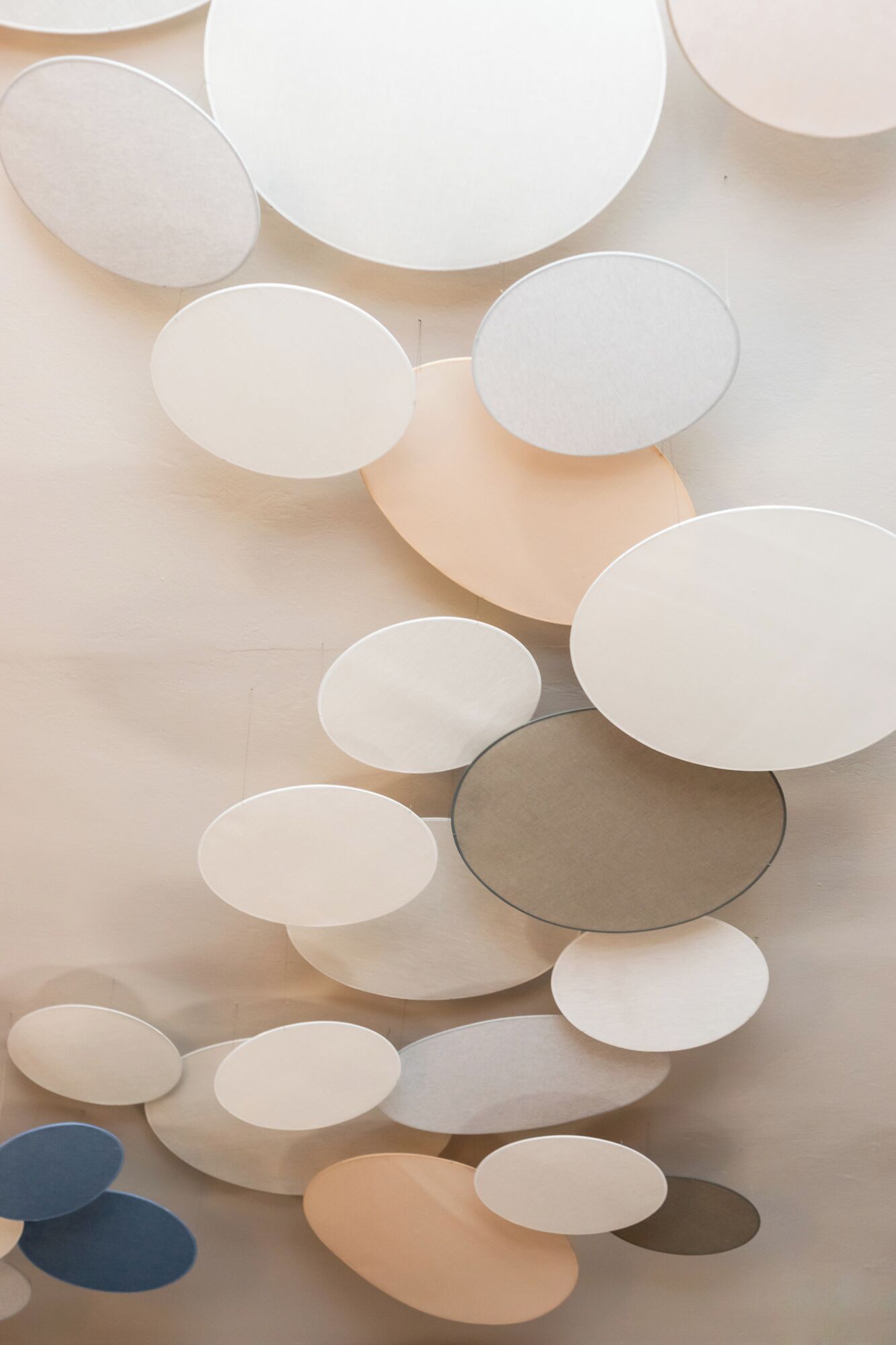 A wall with a series of circular decorations in various sizes and shades of beige.