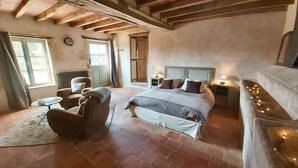 A bedroom with a large bed, a chair, a small table, and a radiator. - To complete (Berd'huis)