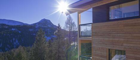A modern building with a balcony overlooking a mountainous landscape.