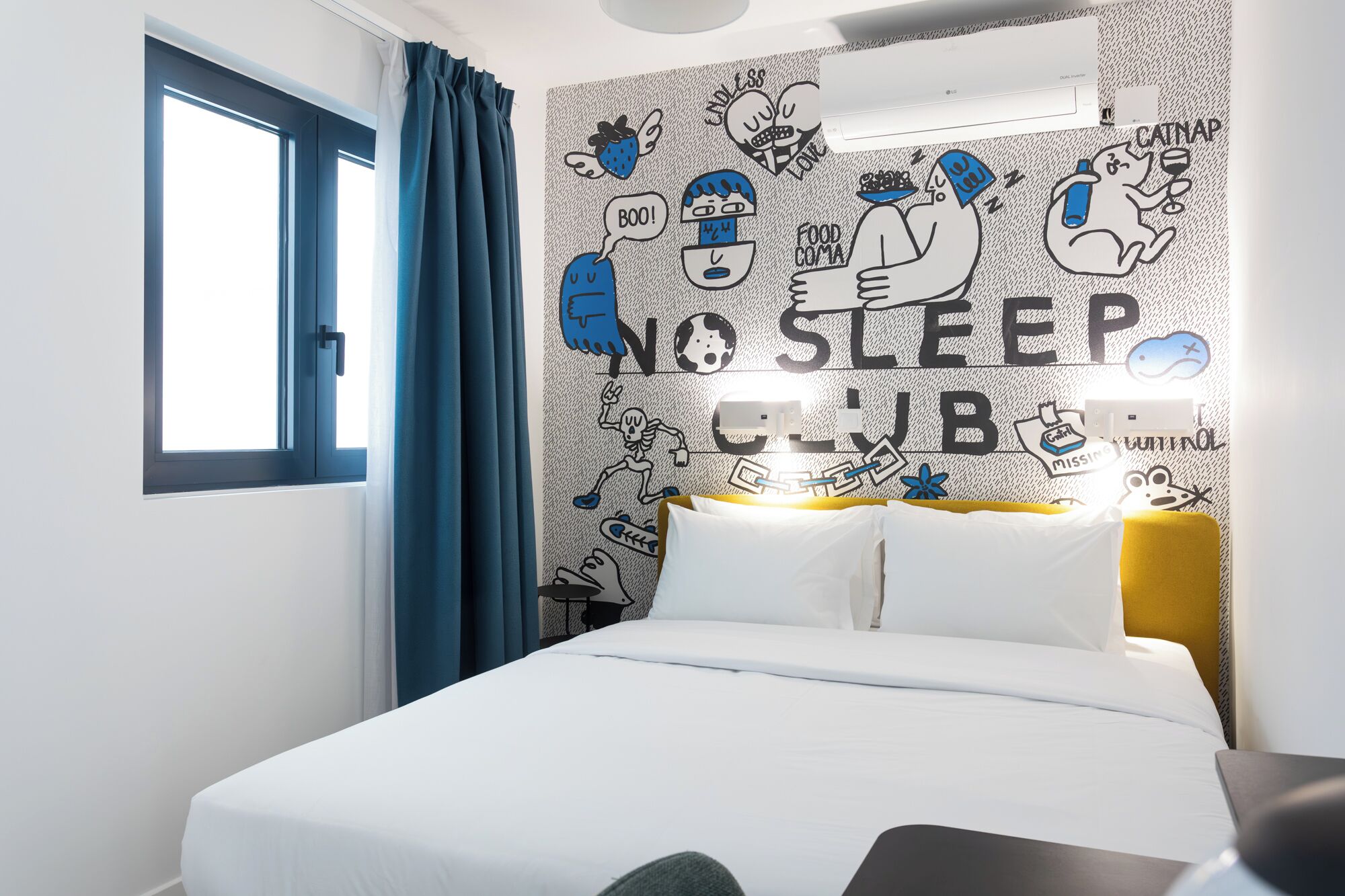 A hotel room with a bed, a window with blue curtains, and a wall with a 'NO SLEEP CLUB' sign.