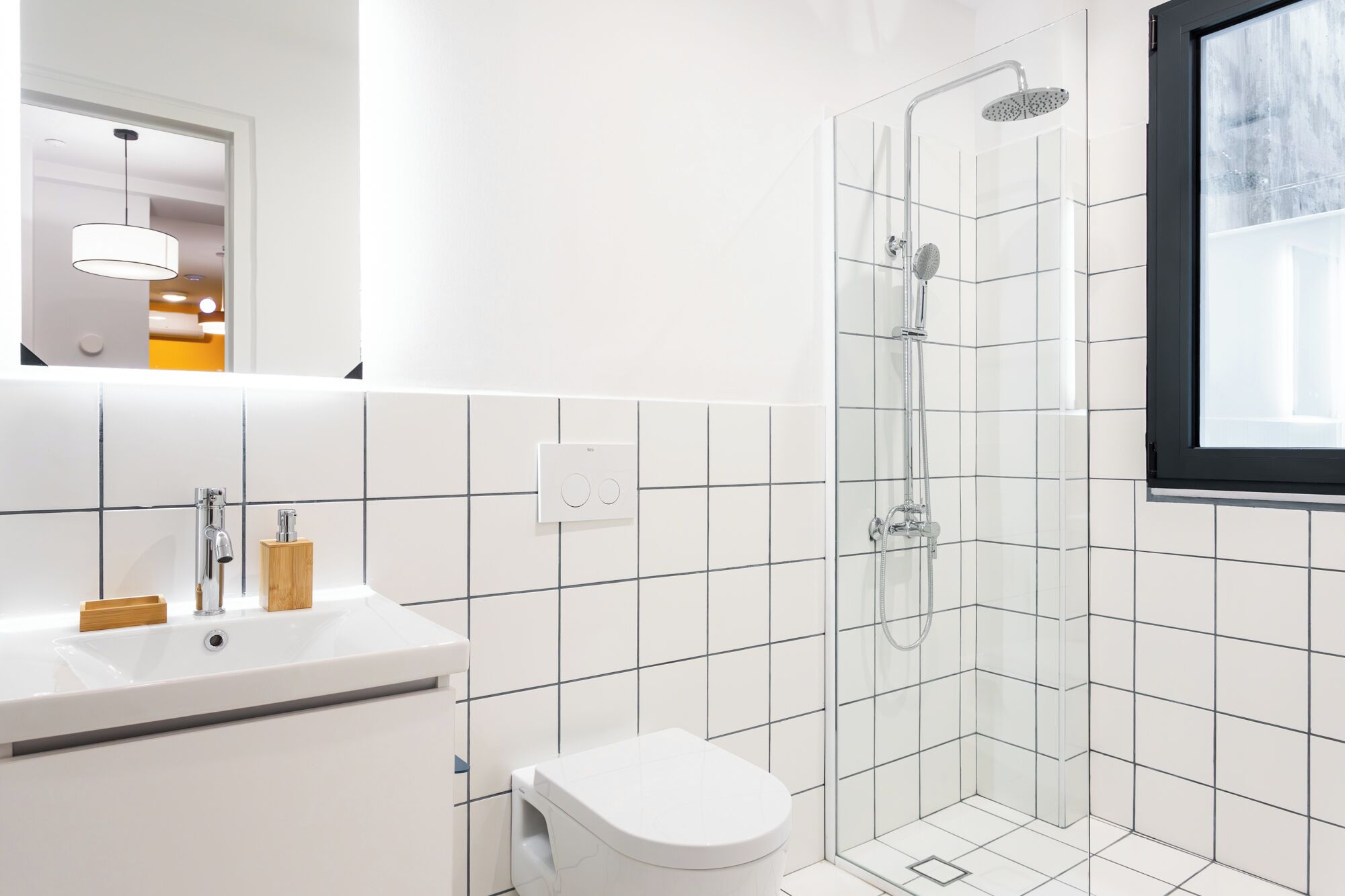 A modern bathroom with a shower, toilet, and sink.