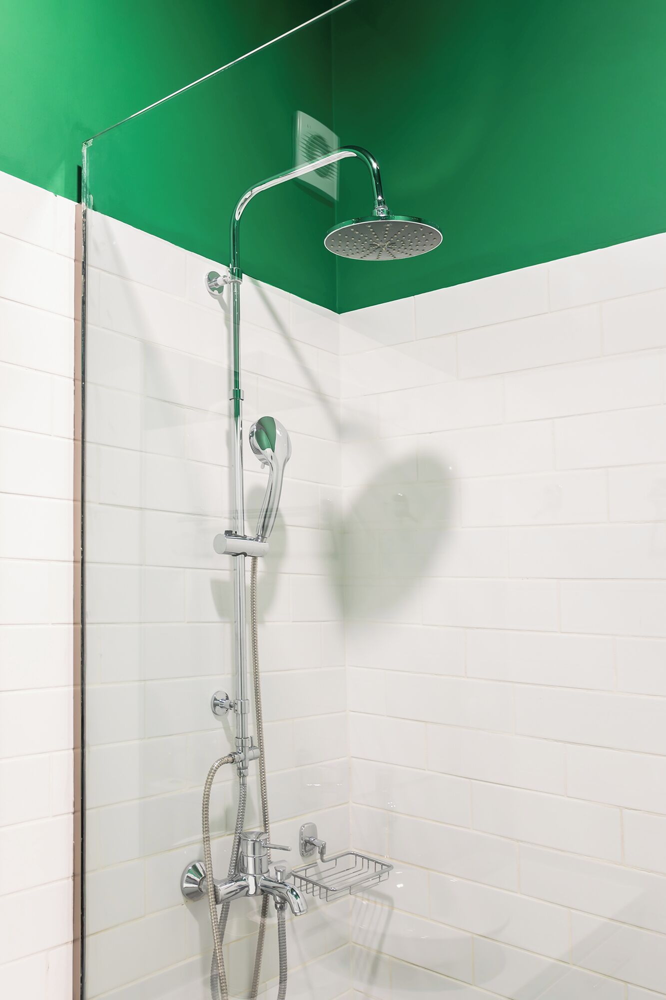 A shower with a rain showerhead, handheld showerhead, and a handheld shower attachment.
