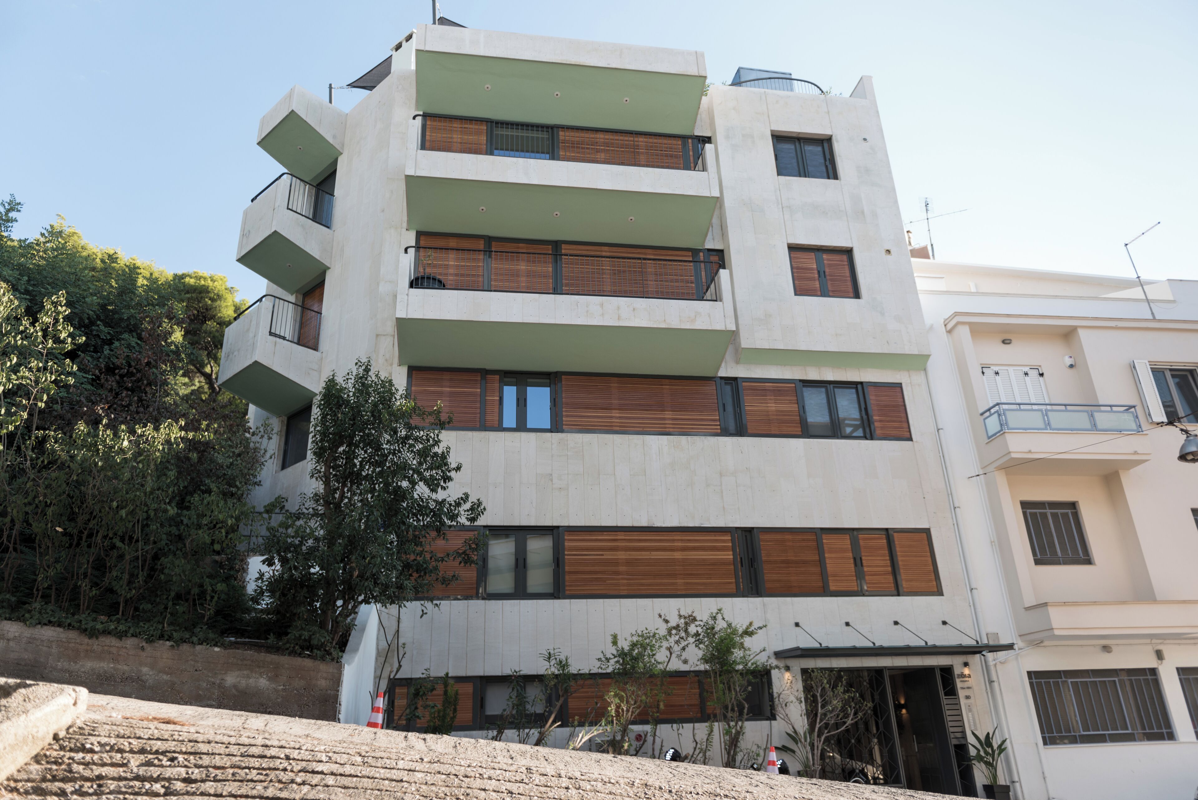 Un immeuble à plusieurs étages, doté de balcons, de grandes fenêtres et d’un toit plat.
