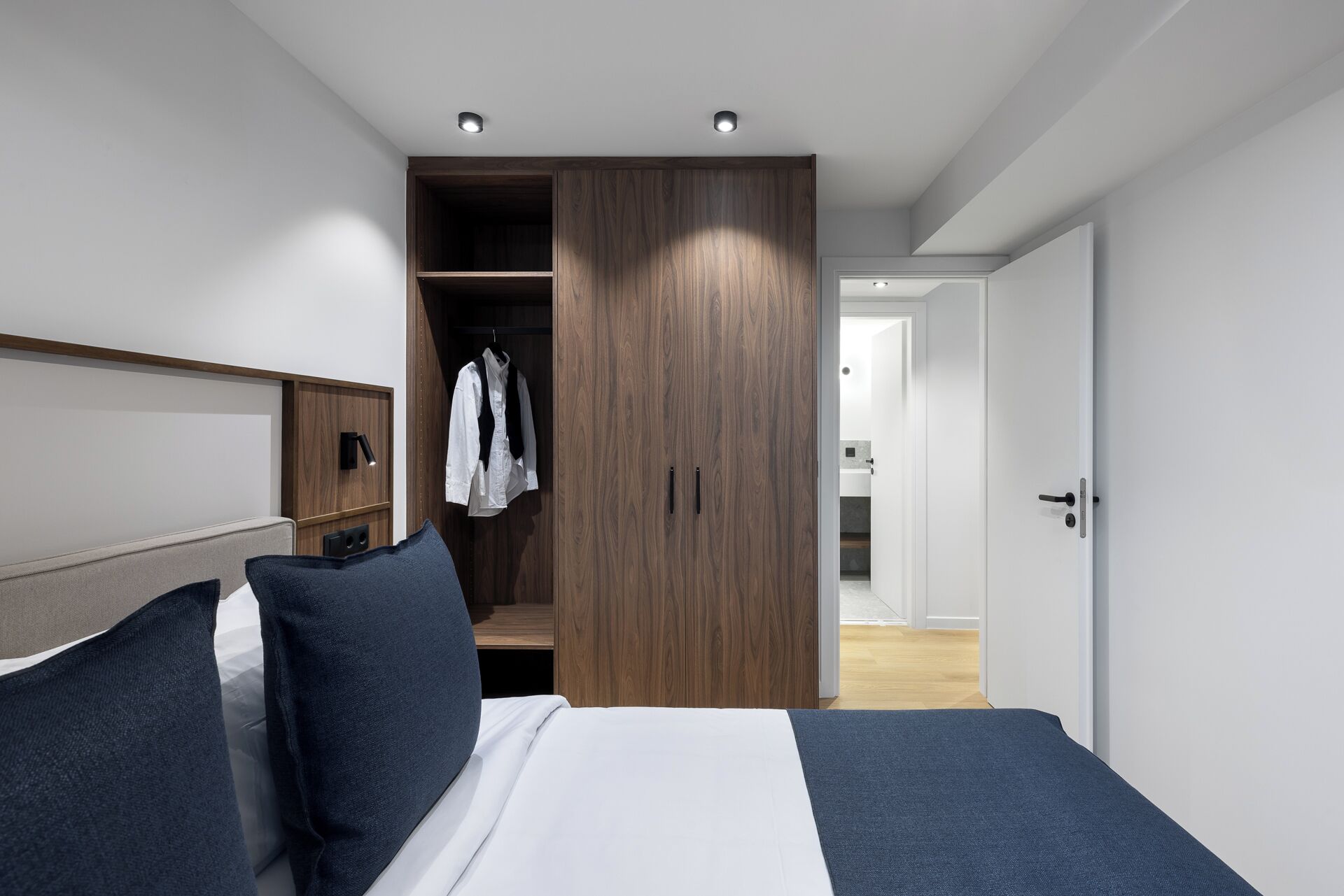 Un dormitorio moderno con una cama grande, un armario y un vestidor.
