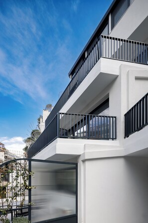 Un edificio moderno de varios pisos con balcones y ventanas amplias.