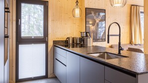 Una cocina moderna con una isla grande, electrodomésticos de acero inoxidable y detalles de madera.