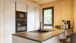 A modern kitchen with built-in appliances, a large window, and a bar area.