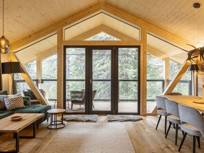 Spazioso loft con soffitto alto, ampie finestre, zona pranzo e angolo salotto accogliente.