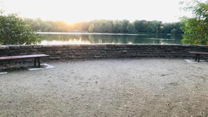 A gravel area with stone walls and benches overlooking a lake. - Airy City Apartment in Zwickau (Zwickau)