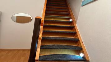 A wooden staircase with carpeted steps and a handrail.
