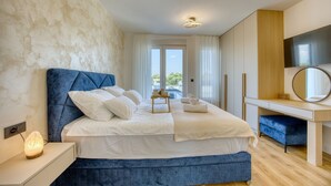A bedroom with a bed, bedside table, and a desk with a chair.