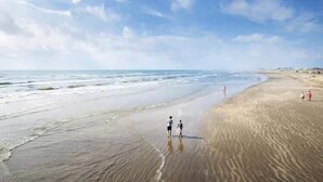 Uma praia com céu claro e mar calmo.