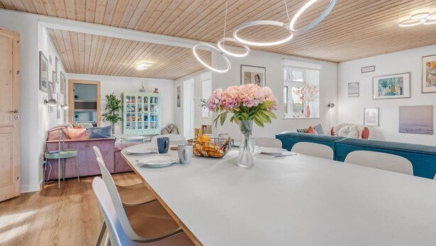 A modern kitchen with a long island, pendant lights, and a vase of flowers. - "Kerttuli" - 540m from the sea by Interhome (Væggerløse)