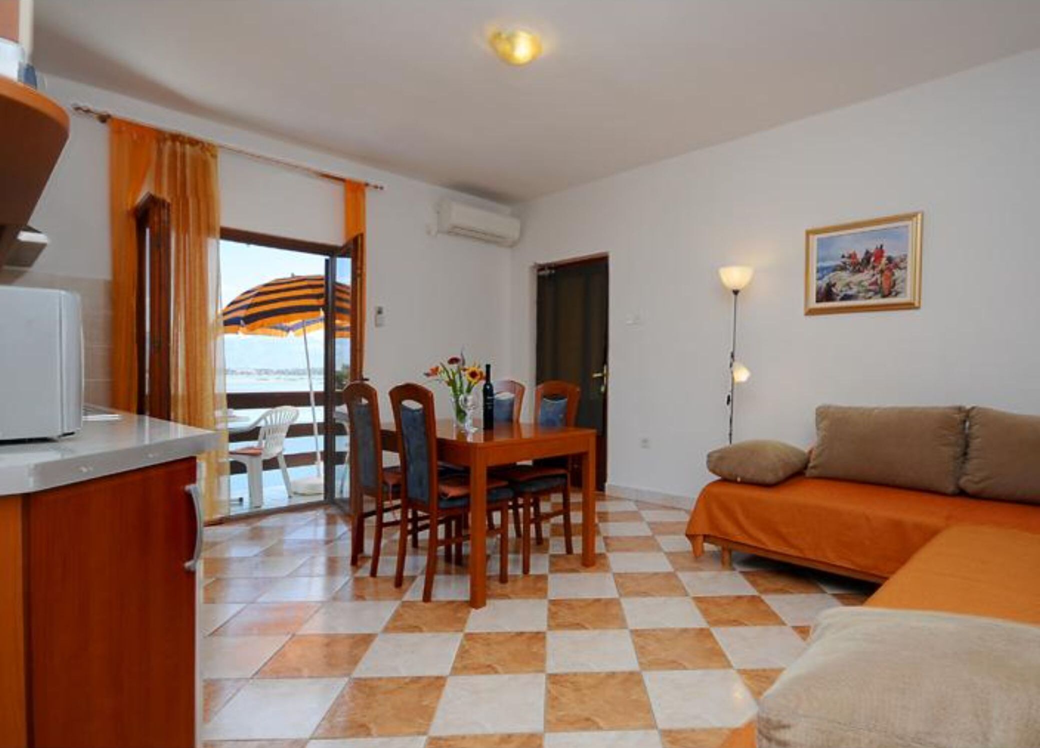 Un espace de vie compact comprenant un coin repas, un canapé et une kitchenette.