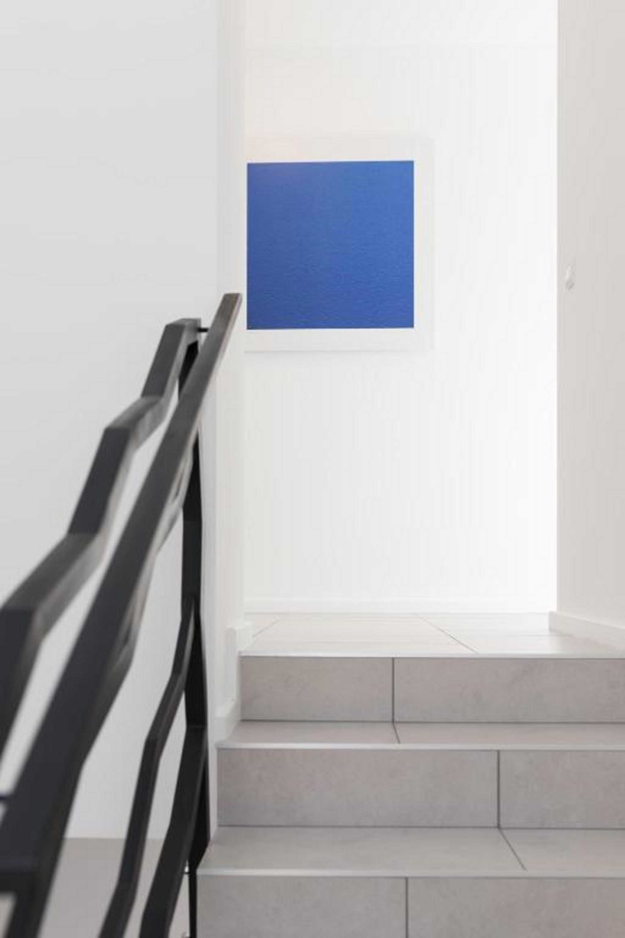 A staircase with a black handrail leading to a landing.