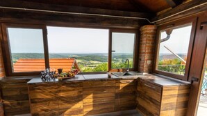 Eine Küche mit großen Fenstern und Blick auf die Landschaft.