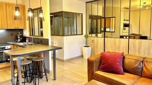 Una cocina moderna con una isla central, taburetes de bar e iluminación colgante.