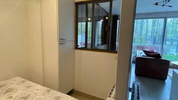 Ein Schlafzimmer mit Bett, Kleiderschrank, Fenster und Blick ins Freie.