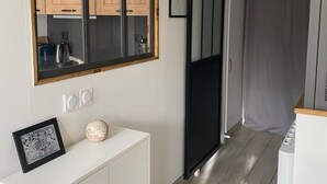 Una cocina moderna con armarios de madera, un espejo con marco negro y una encimera blanca con un marco de fotos y un adorno.