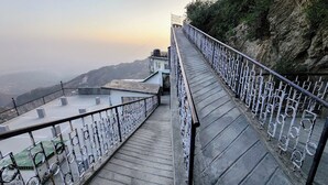 Una escalera conduce a una plataforma panorámica con barandillas de metal y vistas despejadas del paisaje circundante.