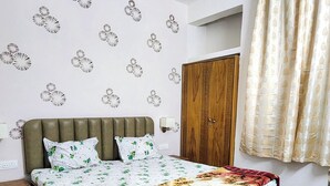 Un dormitorio con una cama, ventilador de techo, armario y paredes con diseño.