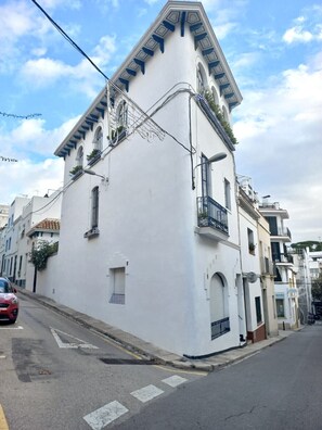 A white building with a triangular roof, multiple windows, and balconies. - HomeHolidaysRentals Suria - Costa Barcelona (Sant Pol de Mar)