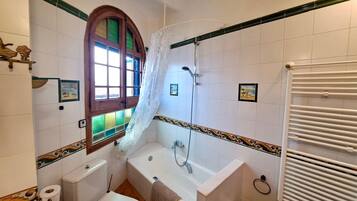 Een badkamer met een bad, toilet en wastafel.