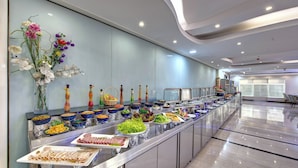 Un bufé con diversos alimentos y un arreglo floral decorativo.