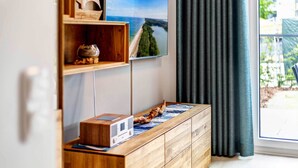 A wooden cabinet with a television mounted on the wall above it.