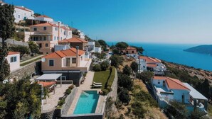 Zona residencial costera con casas, piscina y vista al mar.